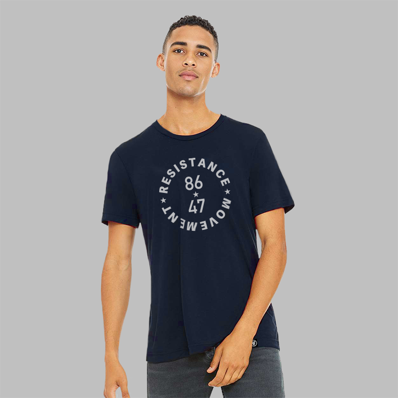 A man wearing a navy blue unisex political t-shirt. The grey text says "86 47"in the middle with"Resistance Movement" around it.