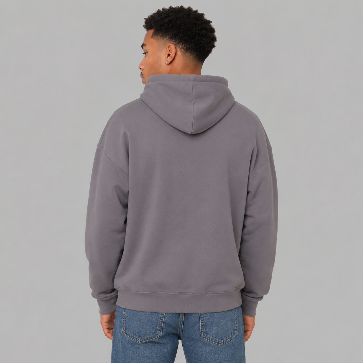 The back of a man wearing a political hoodie that is slate purple. It shows a loose fit and that there are no graphics.