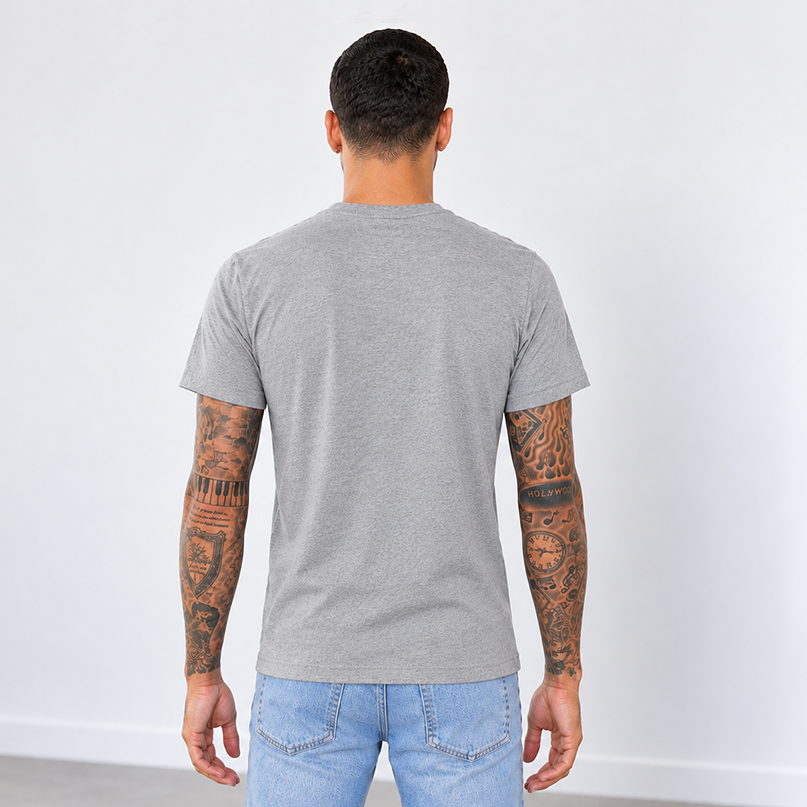 A man viewed from behind wearing a heather ash gray short-sleeve t-shirt to show the unisex fit and that there are no logos on the back.