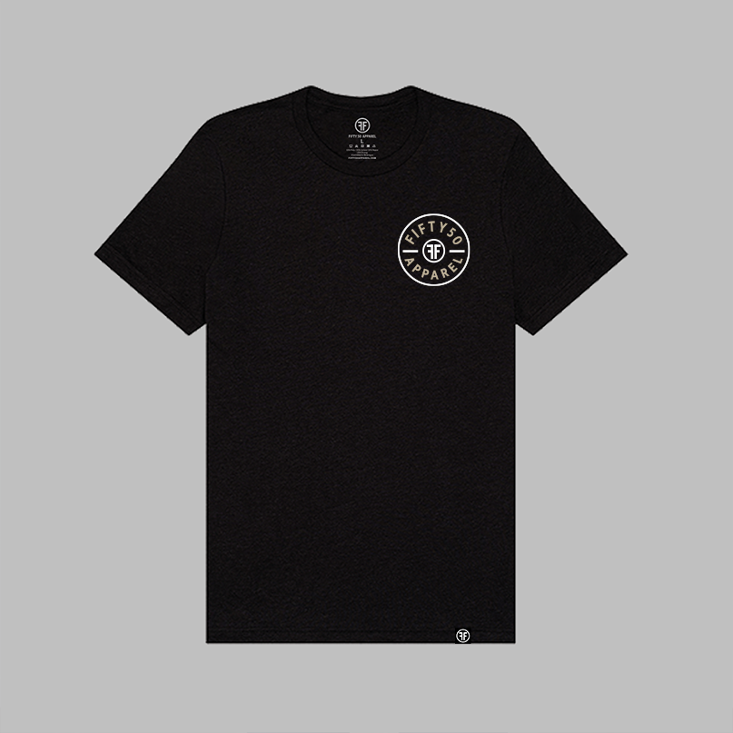 A black crewneck t-shirt with a circular white and light blue graphic on the left chest reading 'FIFTY50 APPAREL'. The shirt is displayed flat against a solid gray background.