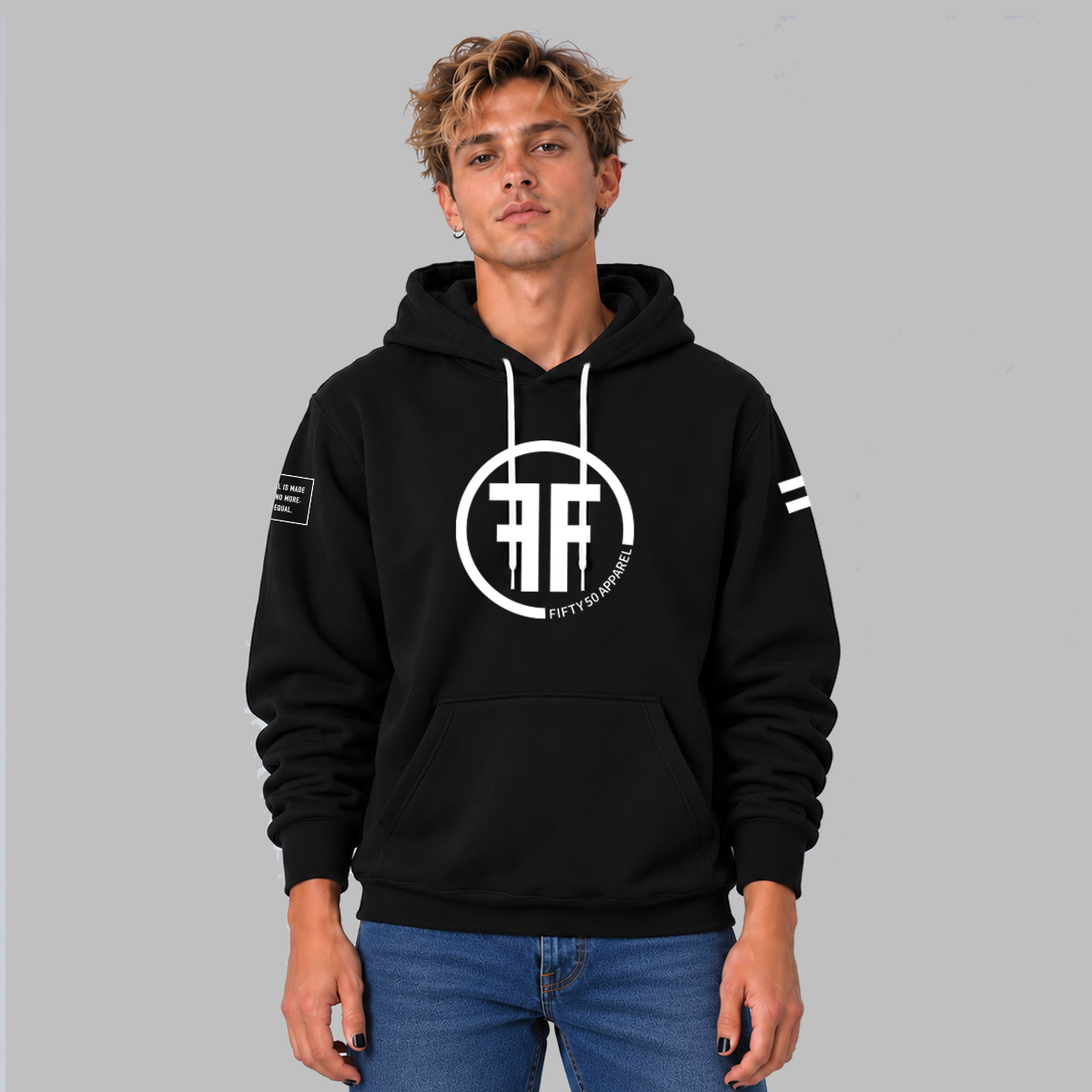 A man wearing a unisex hoodie with a white equal sign on left arm, and the text, 'Fifty 50 Apparel is made for equality, no more, no less, just equal', on the right arm.  Center chest logo has two Fs, back to back with a circle symbolizing balance and equality.