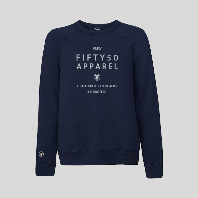 A navy blue crewneck sweatshirt with light grey printed text on the chest reading 'FIFTY50 APPAREL ESTABLISHED FOR EQUALIT' displayed against a solid light gray background.