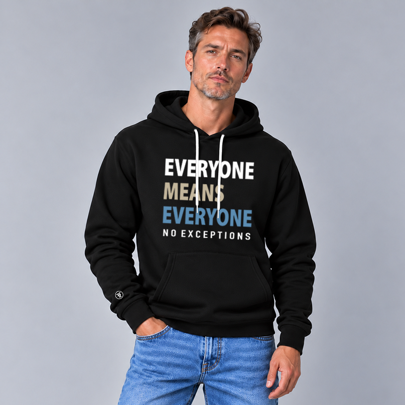 A man modeling a black pullover hoodie with a graphic text print that reads 'EVERYONE MEANS EVERYONE NO EXCEPTIONS' in white, tan, and slate blue. She is wearing light blue jeans against a solid gray studio background.