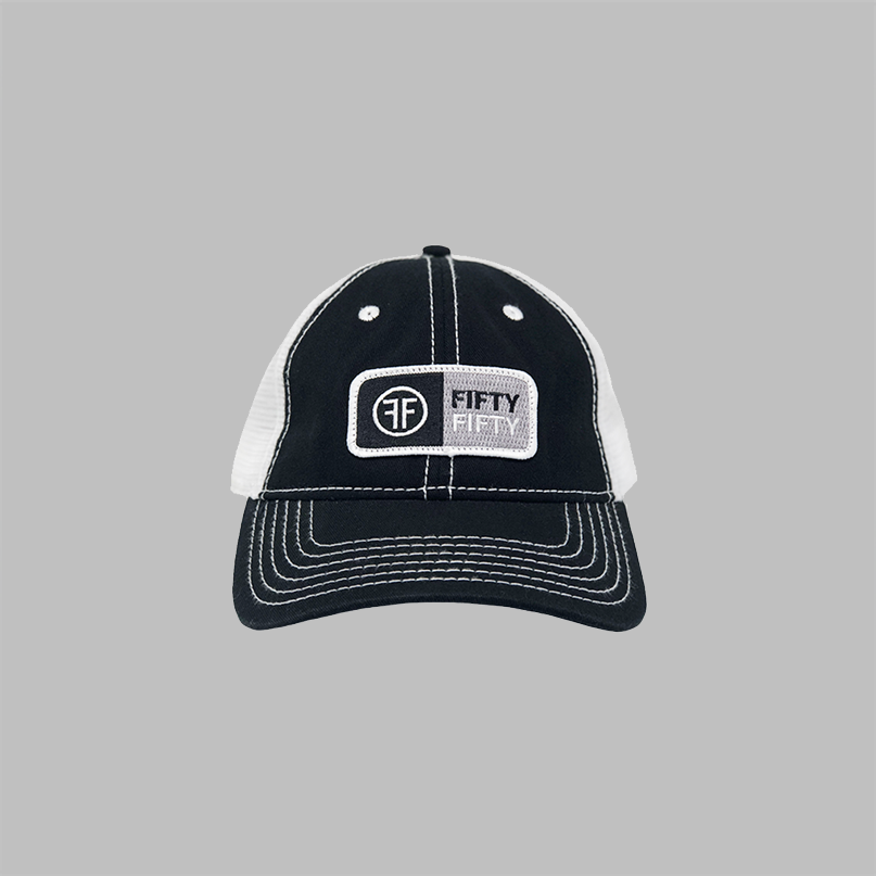 A black trucker with white mesh side panels and white contrast stitching. The rectangular patch is white, grey and black with the text Fifty Fifty.