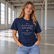 A woman wearing a navy blue graphic t-shirt with light grey text reading 'FIFTY50 APPAREL' and 'Established For Equality Los Angeles'
