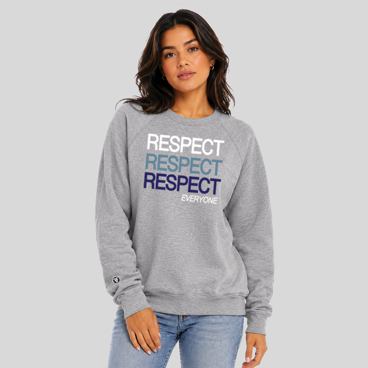 A woman modeling a heather gray crewneck sweatshirt with 'RESPECT' printed in white, light blue, and navy blue across the chest, paired with light-wash jeans against a solid gray background.
