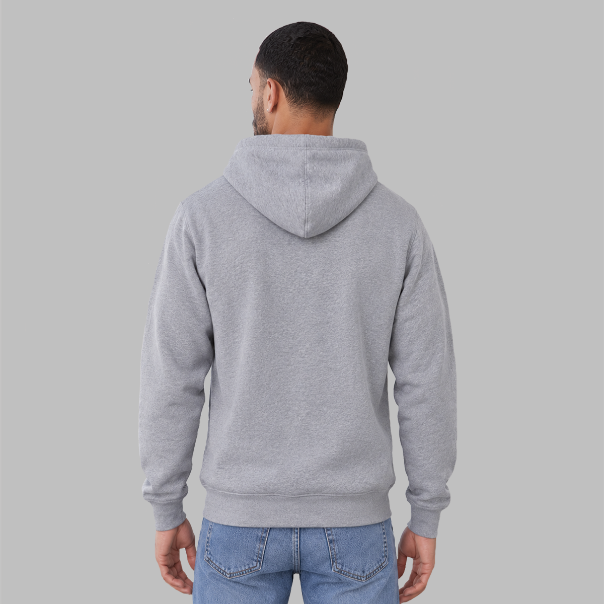 A man viewed from the back wearing a light gray heather pullover hoodie showing the unisex standard fit and fhat there are no logos.