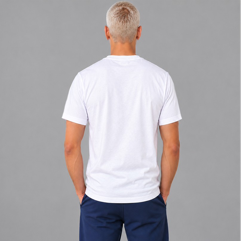 A man viewed from the back wearing a plain white short-sleeve crew-neck t-shirt showing a unisex fit and no graphics on the back, paired with navy blue pants, set against a solid gray studio background.