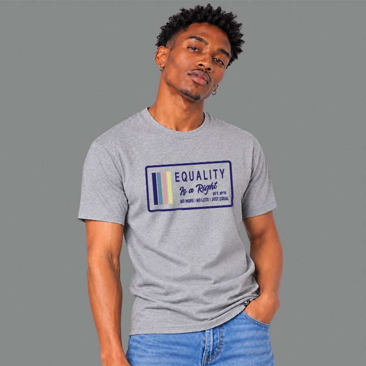 A man wearing a light ash grey graphic t-shirt with a navy, stone blue, pink and yellow design that says 'EQUALITY IS A RIGHT', 'NO MORE NO LESS JUST EQUAL' with a solid gray studio background.