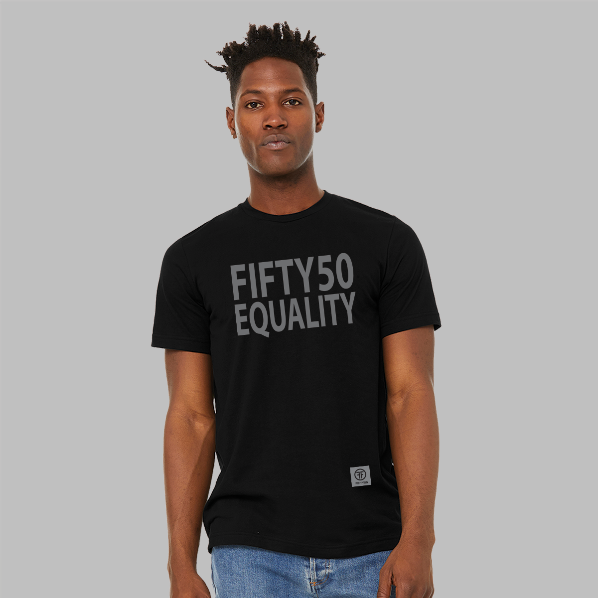 A man wearing a black equality tshirt. The text is in large, grey, bold font and says Fifty50 with Equality below it. 