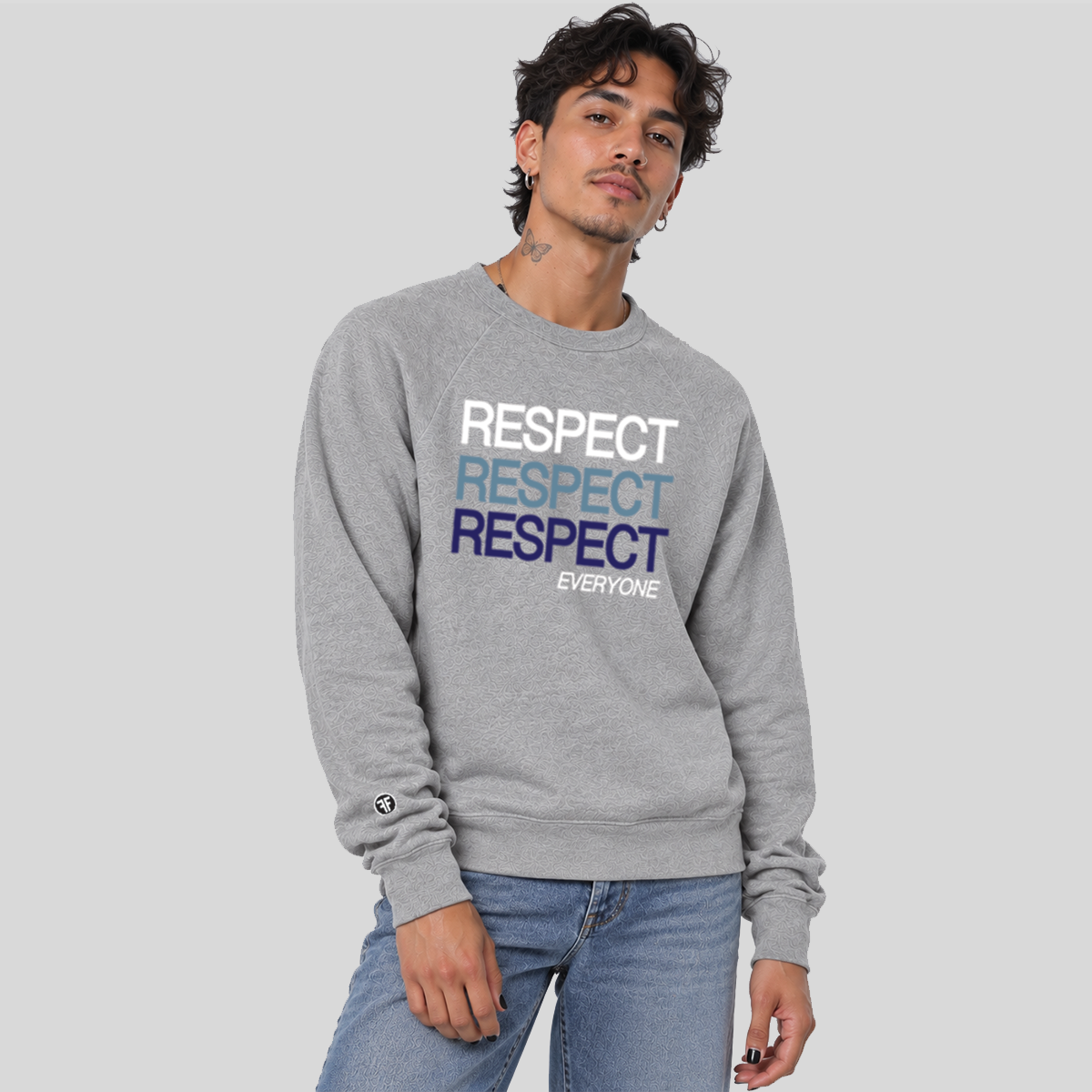 A man wearing an ash gray crewneck sweatshirt with stacked 'RESPECT' text in white, light blue, and navy blue on the chest, paired with light blue jeans, against a solid gray background.