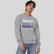 A man wearing an ash gray crewneck sweatshirt with stacked 'RESPECT' text in white, light blue, and navy blue on the chest, paired with light blue jeans, against a solid gray background.