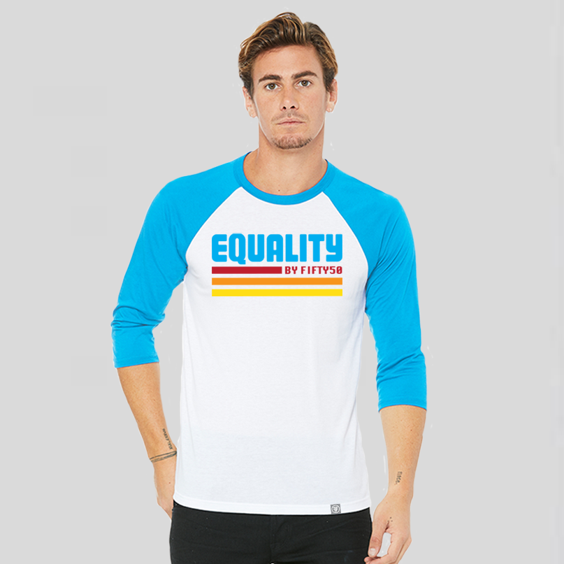 A man wearing a white baseball t-shirt that has turquoise arms and collar. The logo text says Equality, in turquoise, retro font with lines of red, orange, and yellow beneath. 