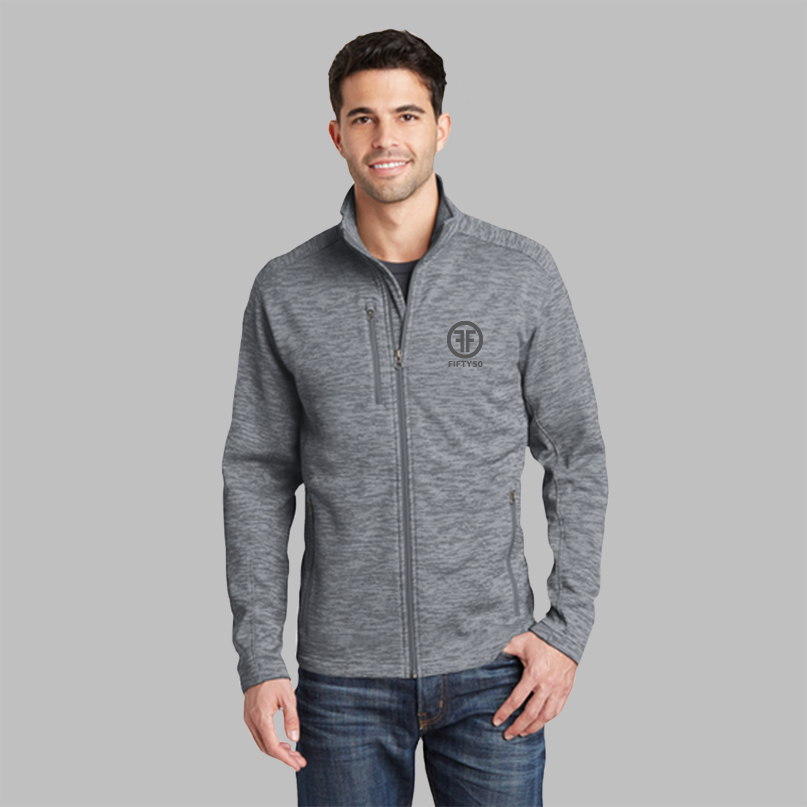 A man wearing a grey jacket with two zippered side pockets, and a zippered right chest pocket. There is a grey embroidered logo on the left chest that has two Fs, back to back, with the text Fifty50