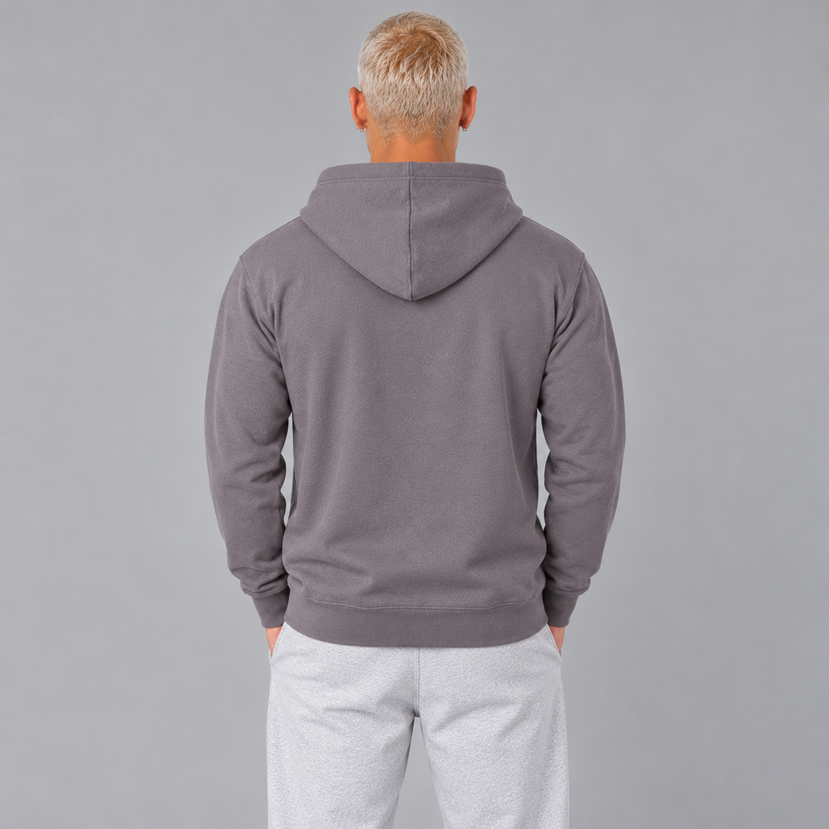 The back of a man wearing a slate purple hoodie showing a loose fit and that there are no graphics.