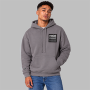 A man wearing a slate purple pullover hoodie with a black chest logo that reads 'resist resist resist' in white, light grey, and dark grey text, paired with blue jeans, against a solid gray background.