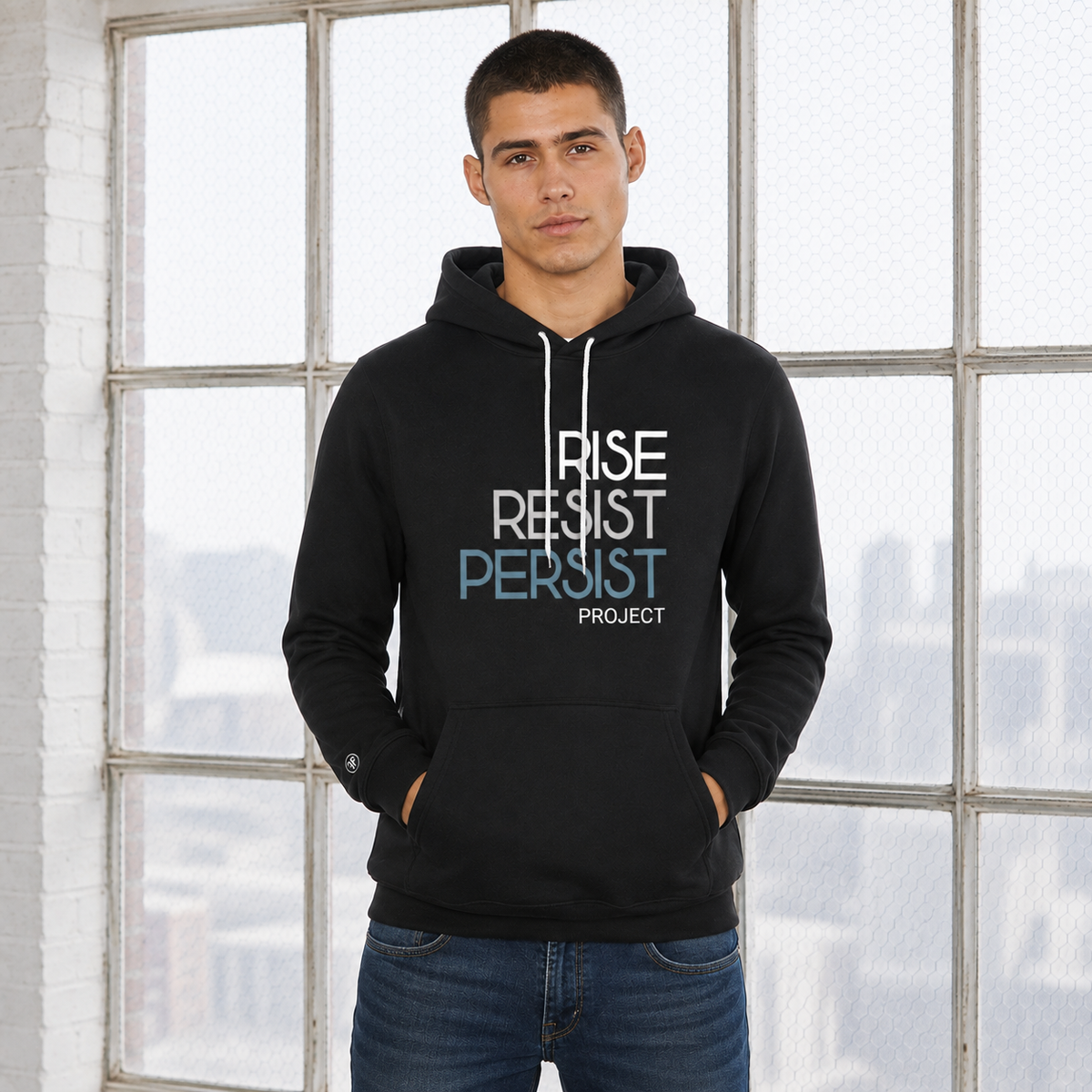 A man wearing a anti-Trump, political unisex black hoodie. The text says Rise, Resist, Persist, Project. The font is white, Slate Blue, and grey.