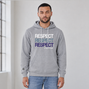 A man wearing an ash gray pullover hoodie with a stacked 'RESPECT' graphic in white, light blue, and navy blue on the chest, paired with blue jeans in a bright, minimalist room.