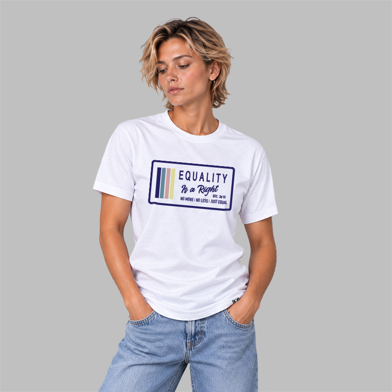 A woman wearing a white graphic t-shirt with a navy, stone blue, pink and yellow design that says 'EQUALITY IS A RIGHT', 'NO MORE NO LESS JUST EQUAL' with a solid gray studio background.
