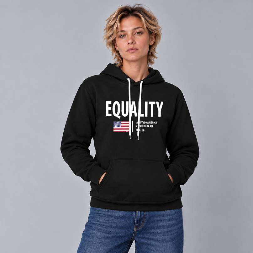 A woman wearing a black pullover hoodie with a white graphic print that reads 'EQUALITY' and 'A FIFTY50 AMERICA CREATED FOR ALL USA, CA.'