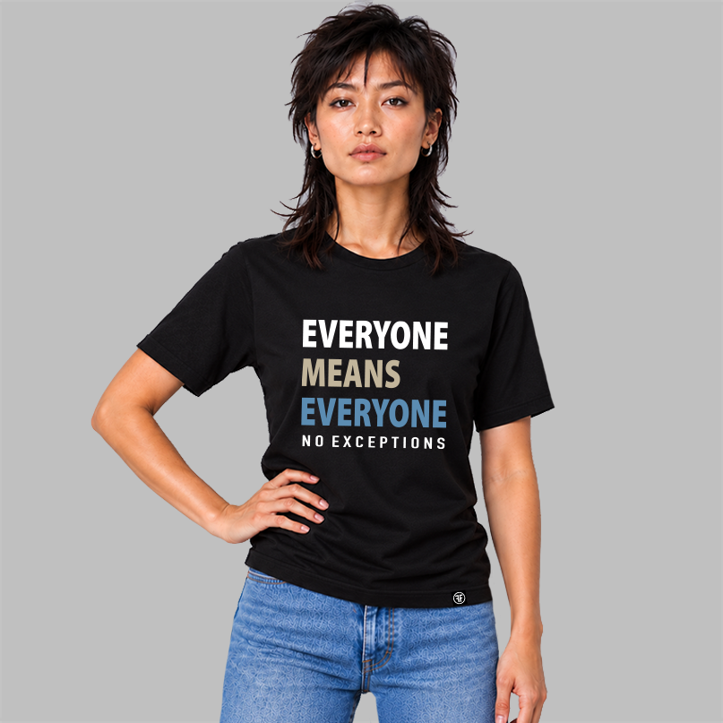 A woman wearing a black graphic t-shirt with the text 'EVERYONE MEANS EVERYONE NO EXCEPTIONS' in white, beige, and slate blue, paired with blue jeans, set against a solid gray background.