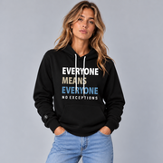 A woman modeling a black pullover hoodie with a graphic text print that reads 'EVERYONE MEANS EVERYONE NO EXCEPTIONS' in white, tan, and slate blue. She is wearing light blue jeans against a solid gray studio background.