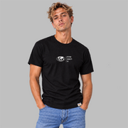 A man wearing a  black short-sleeve t-shirt with a white graphic center chest featuring a globe and the text 'FIFTY50 EQUALITY CO. Paired with jeans, set against a solid gray background.