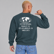 A man shown from the back wearing a slate teal crewneck sweatshirt with a white graphic on the back. The graphic features a globe design above the text 'FIFTY50 APPAREL EQUALITY CO. EST. LOS ANGELES, CA SINCE 2015'.