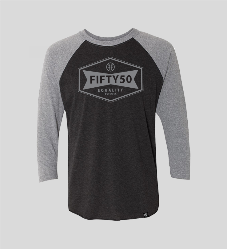 A heather black baseball equality tshirt, with a grey collar and arms, and a grey logo. The logo is a narrow, yet wide hexagon with text that says Fifty50, Equality, Established 2015 inside of it.
