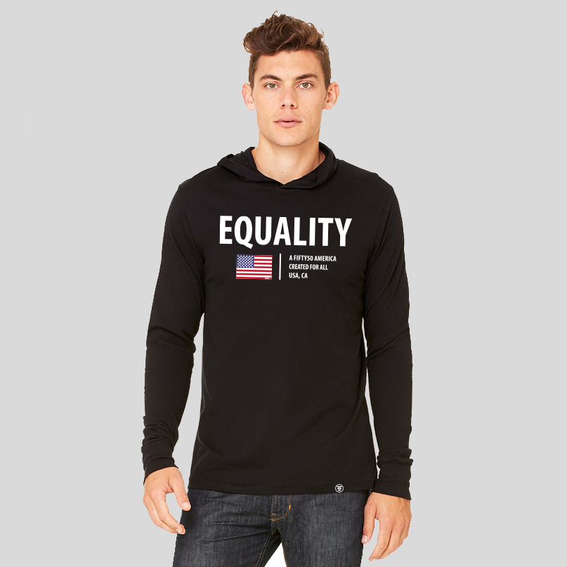 A man wearing a black jersey hoodie, with  the text, Equality, written in white bold font. Under that there is an American flag and the text, A fifty 50 America created for all.